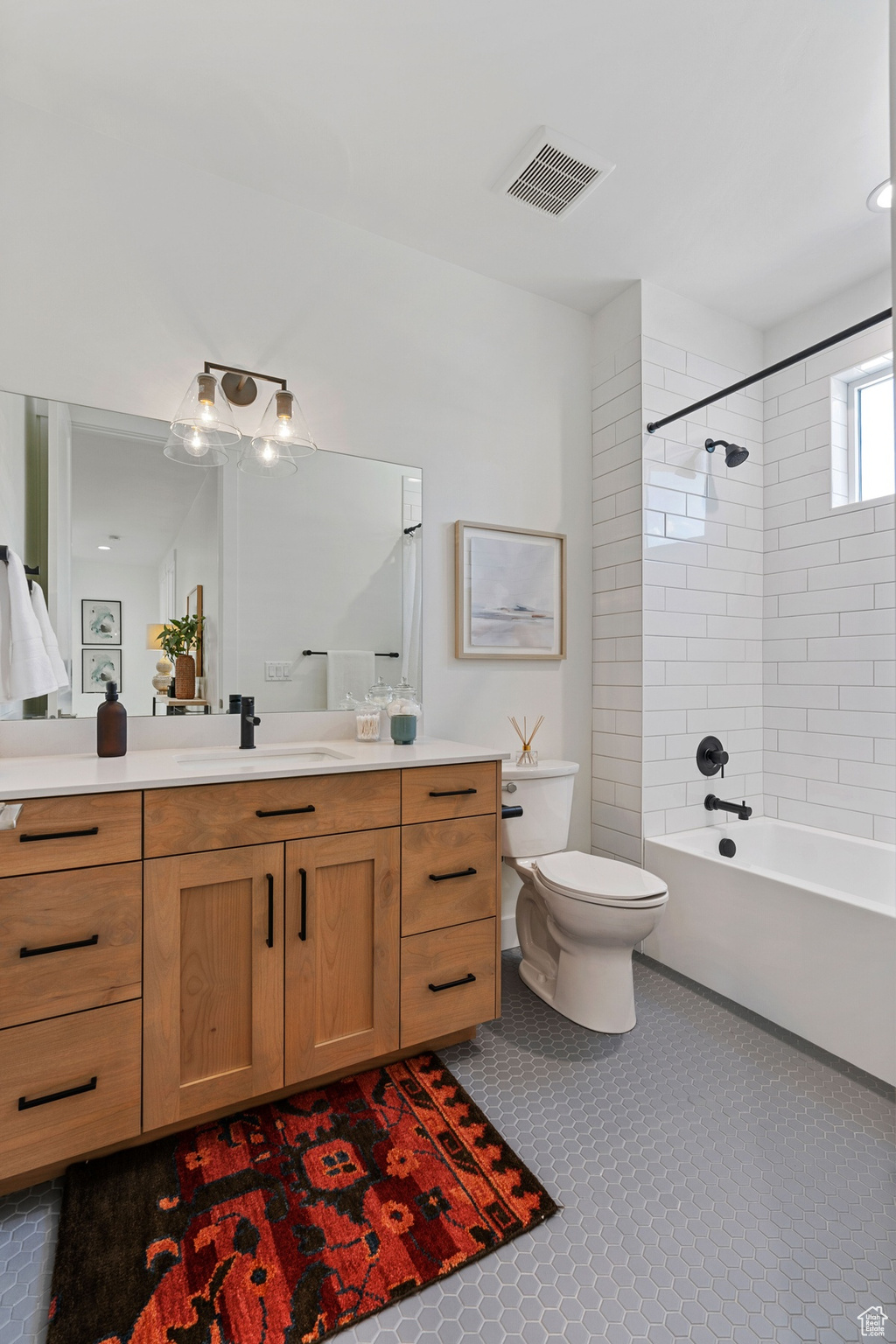 Full bath with visible vents, toilet, tile patterned flooring, vanity, and shower / washtub combination