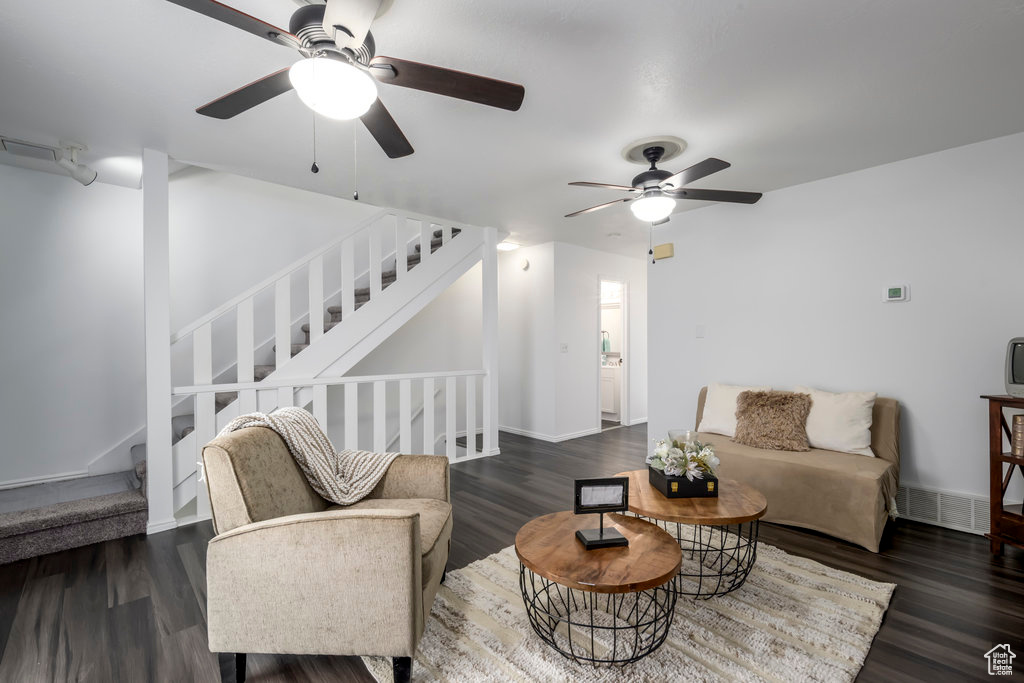 Living room featuring visible vents, stairs, baseboards, and dark wood-style flooring