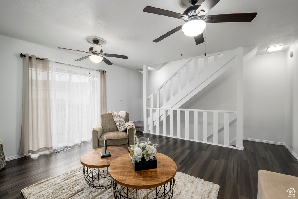 Sitting room with stairs, dark wood finished floors, and baseboards