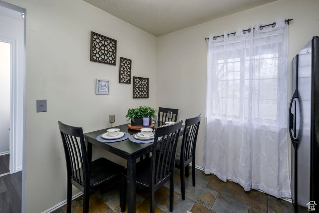 Dining space with baseboards and stone finish floor
