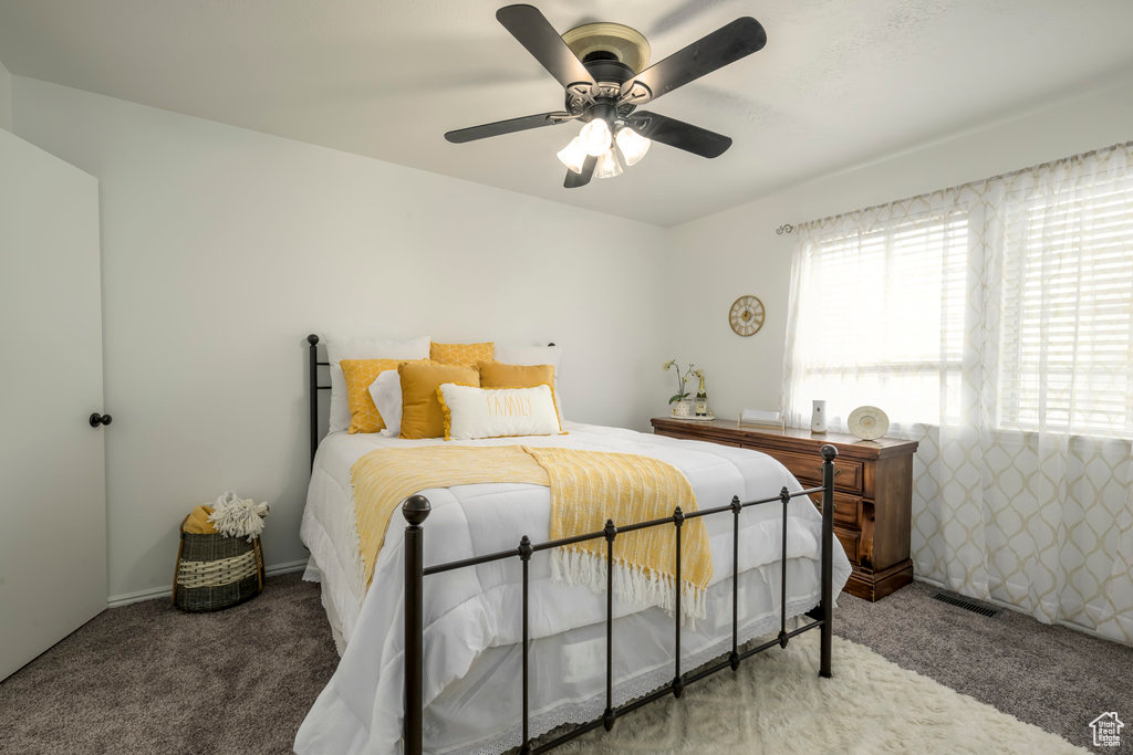 Bedroom featuring a ceiling fan, carpet flooring, and visible vents