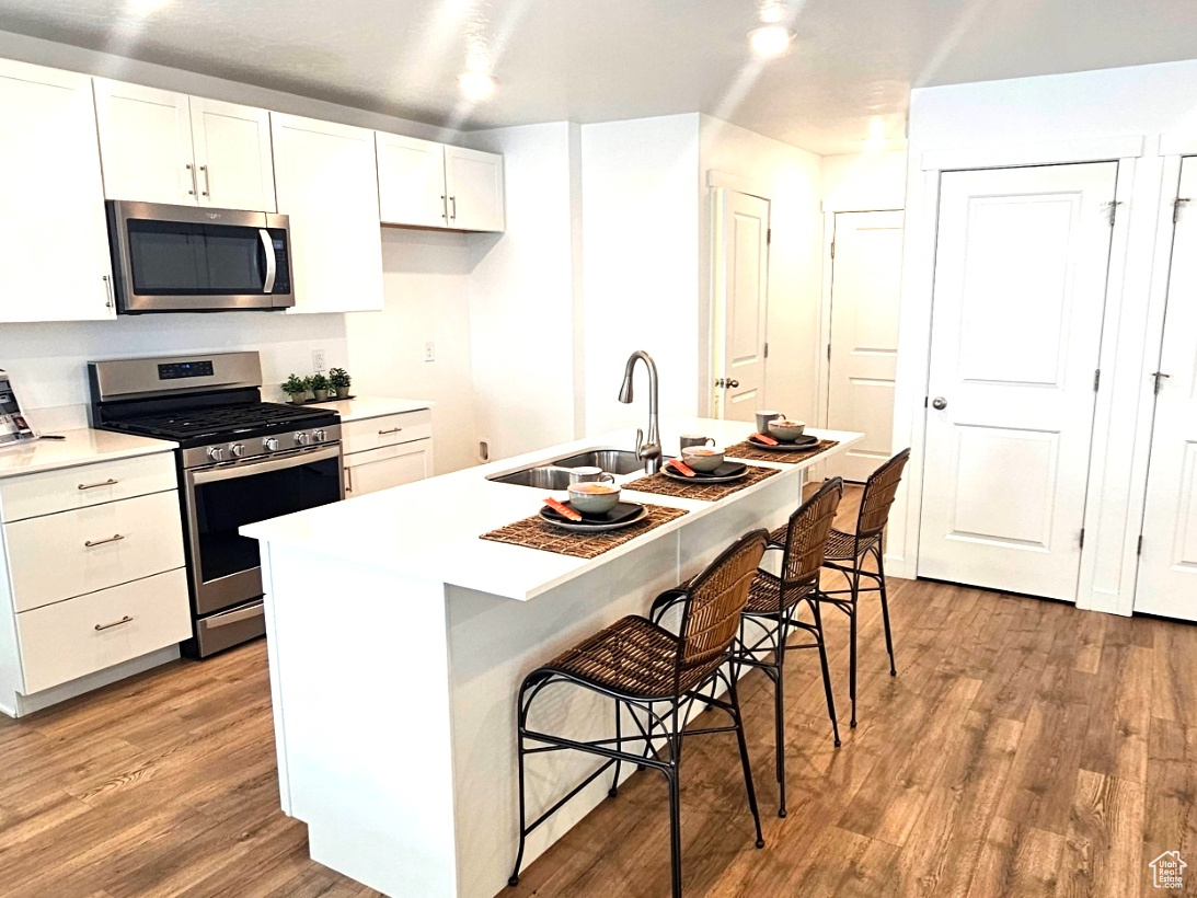 Kitchen with white cabinets, stainless steel appliances, and island