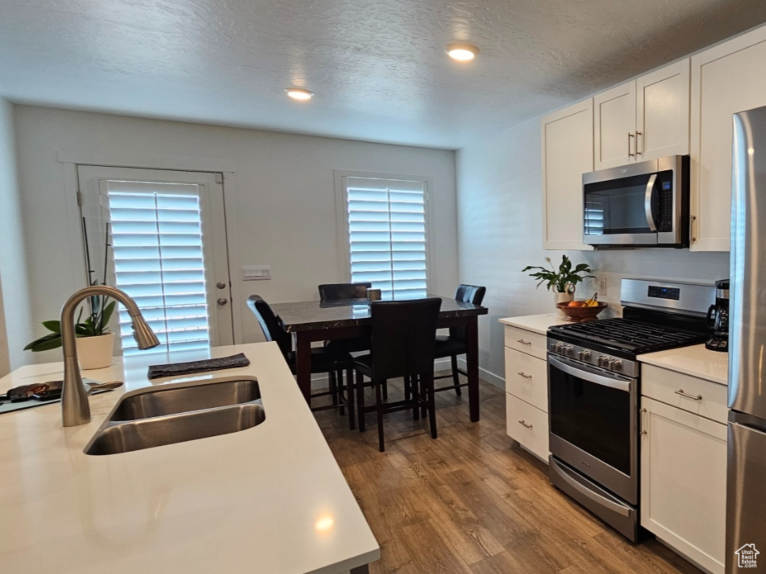 Kitchen with white cabinetry, silestone countertops and stainless steel appliances