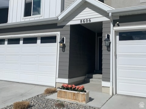 Property entrance featuring a garage, board and batten siding, and driveway