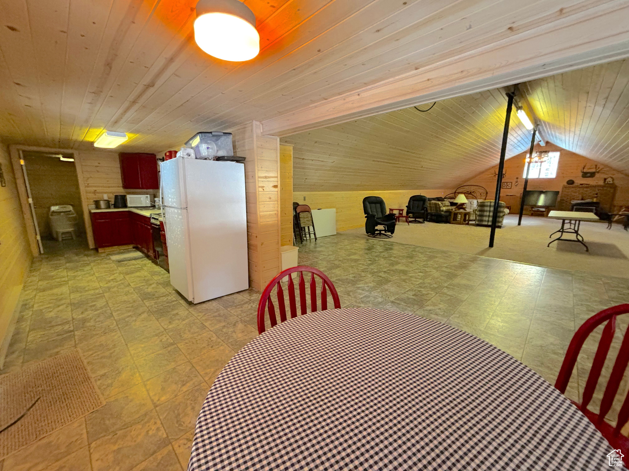 Dining area featuring wooden ceiling, vaulted ceiling, and wood walls