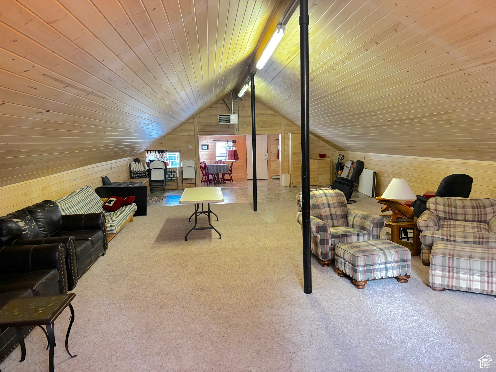 Interior space with lofted ceiling, wooden ceiling, and wooden walls