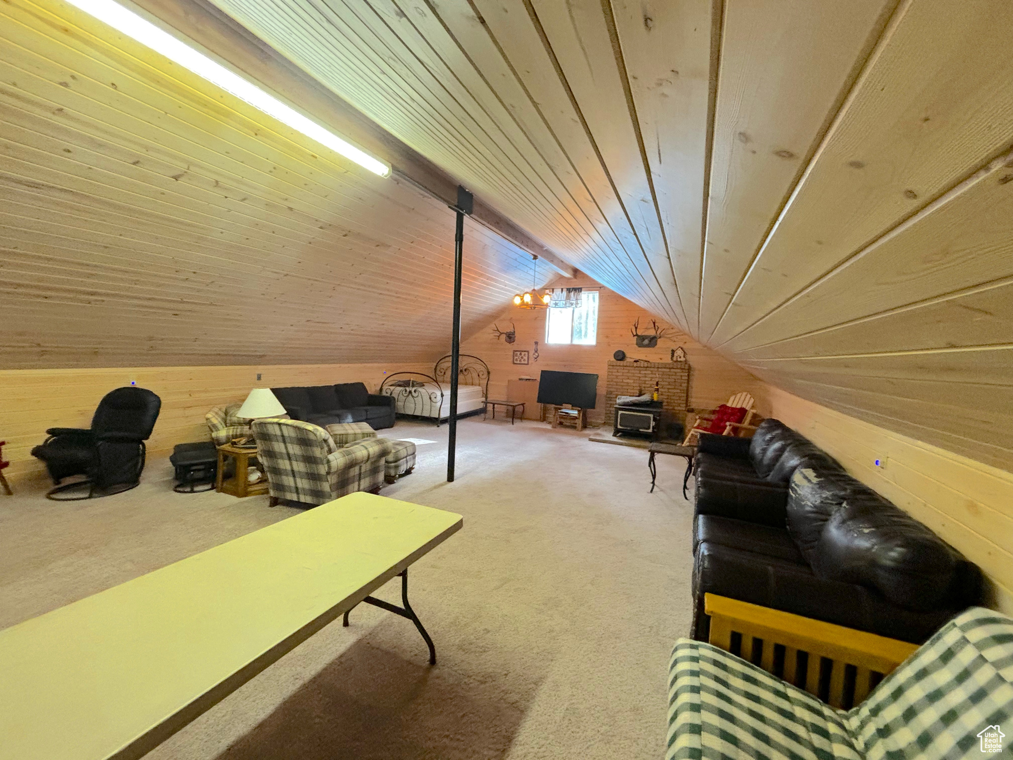 Additional living space with vaulted ceiling, carpet, wooden ceiling, and wooden walls