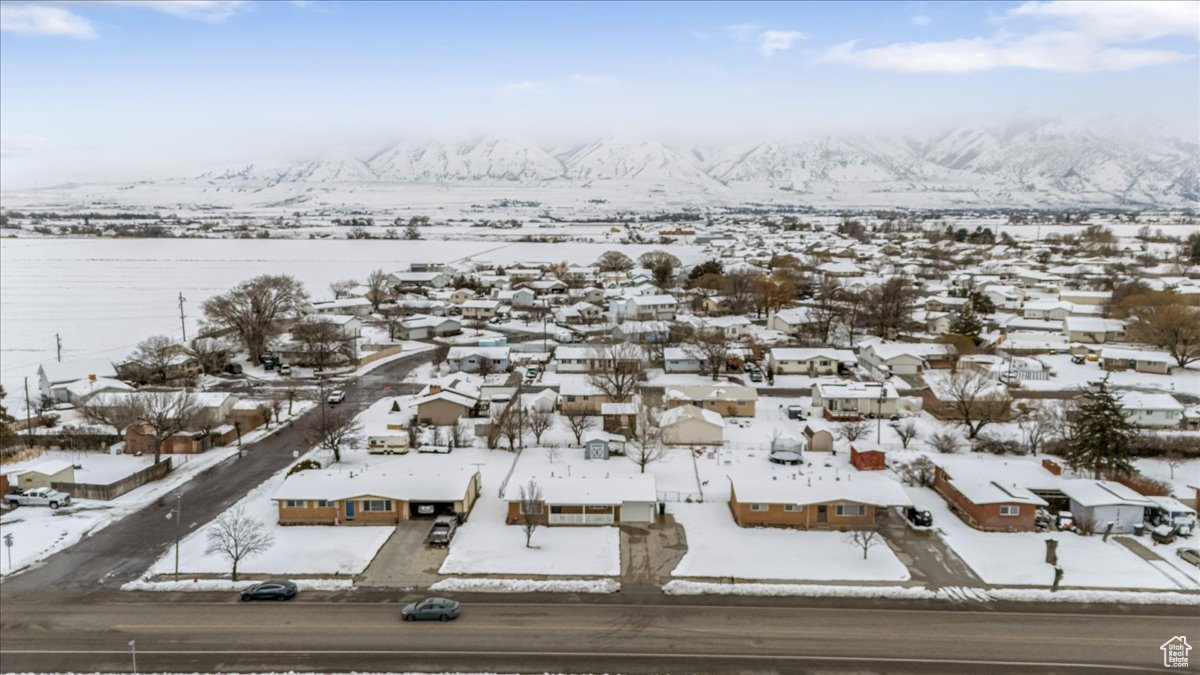 Snowy aerial view featuring a residential view and a mountain view