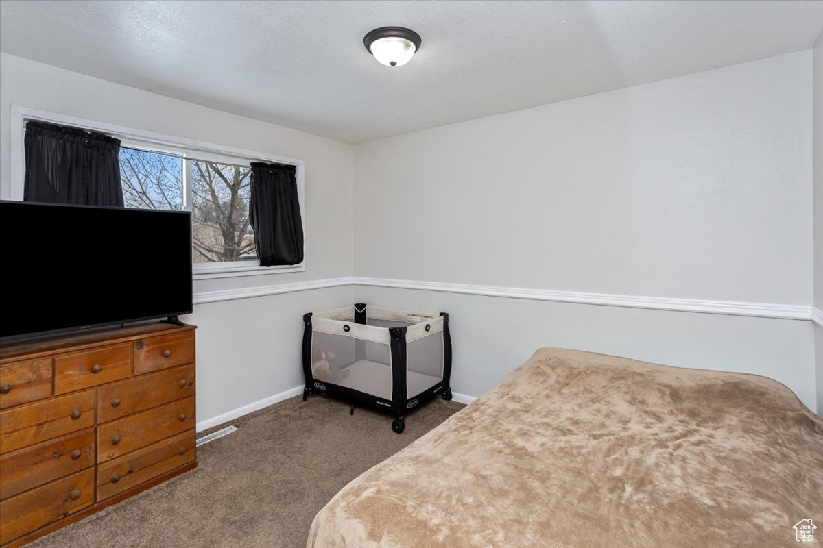Bedroom featuring carpet and baseboards