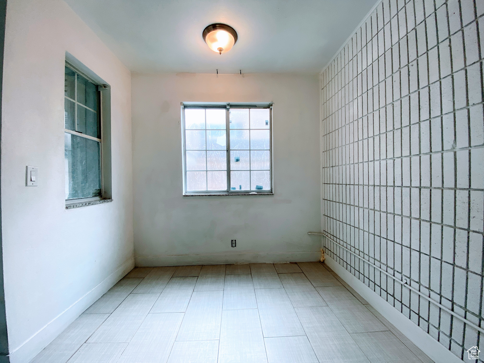 Empty room featuring tile walls