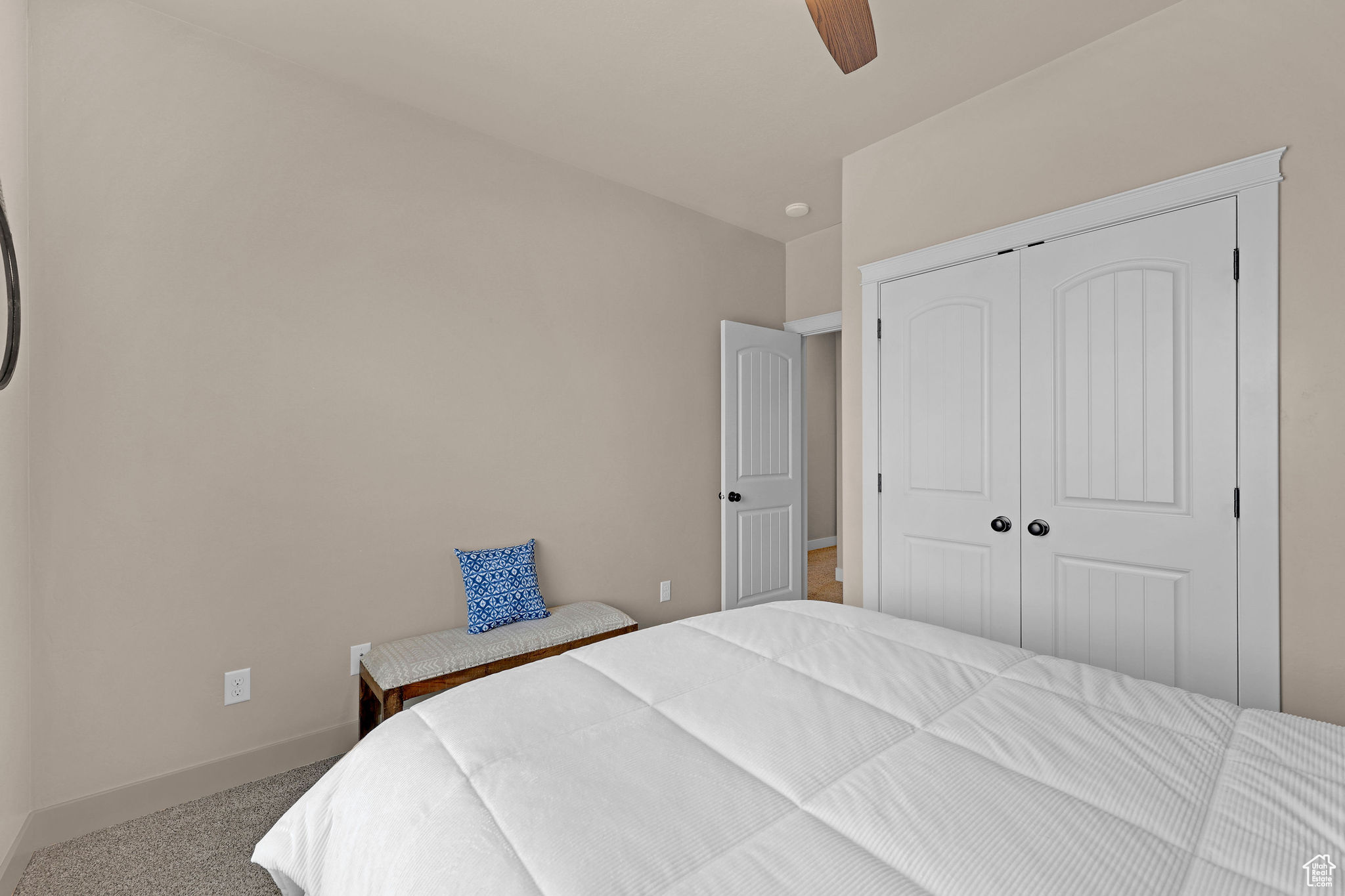 Carpeted bedroom featuring a closet and ceiling fan