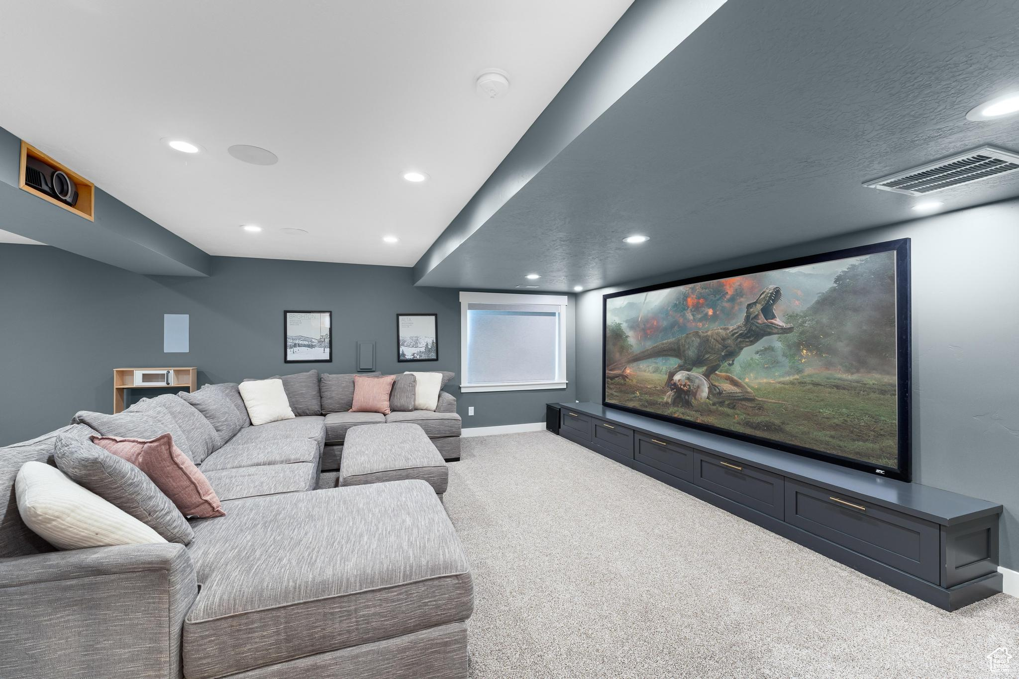Carpeted home theater room with recessed lighting
