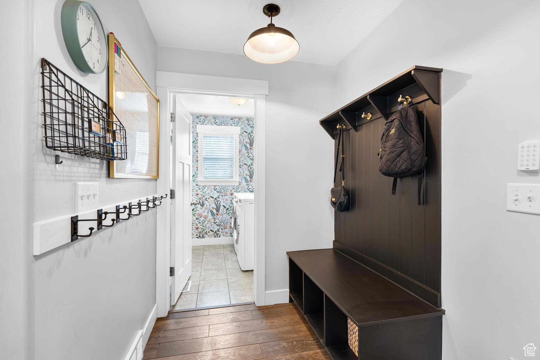 Mudroom featuring s bench, shoe cubby, coat hangers and finished floors