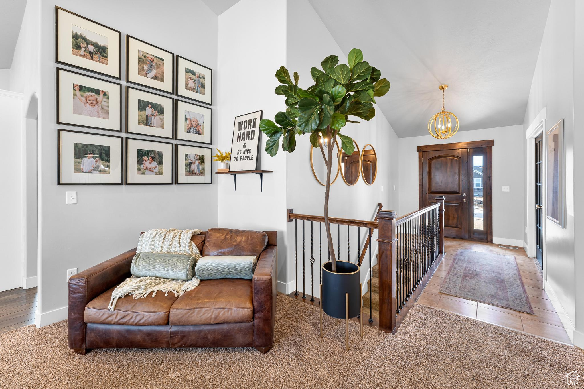 Interior space featuring lofted ceiling, tile patterned floors,  and an inviting chandelier