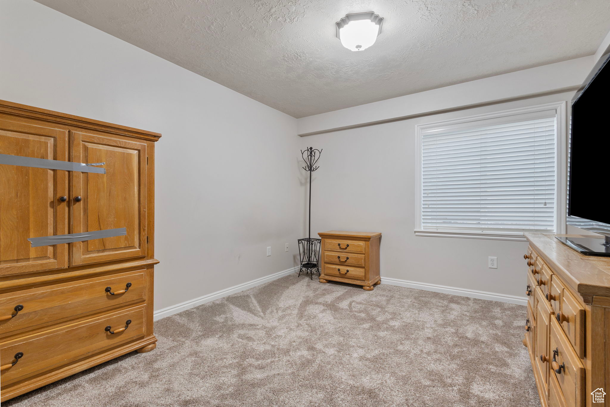 Interior space with light carpet and a textured ceiling