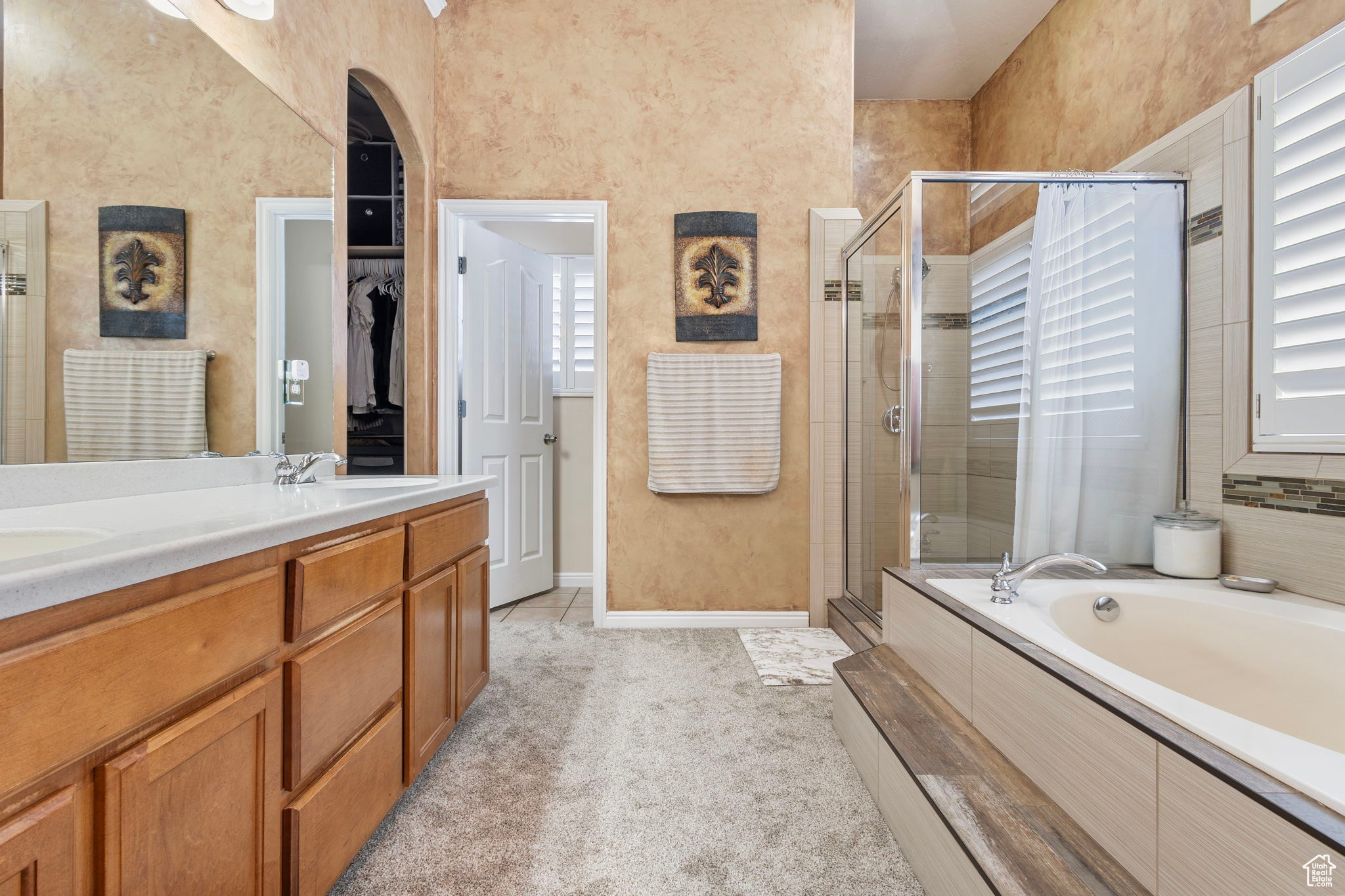 Bathroom featuring vanity, independent shower and bath, and tile patterned flooring