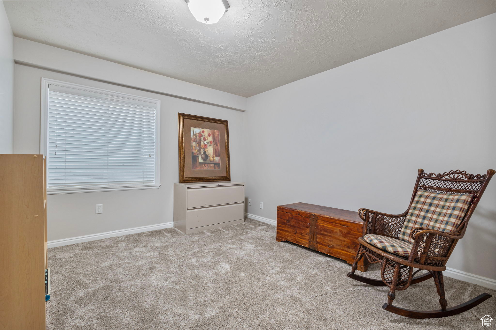 Sitting room with a textured ceiling and light colored carpet