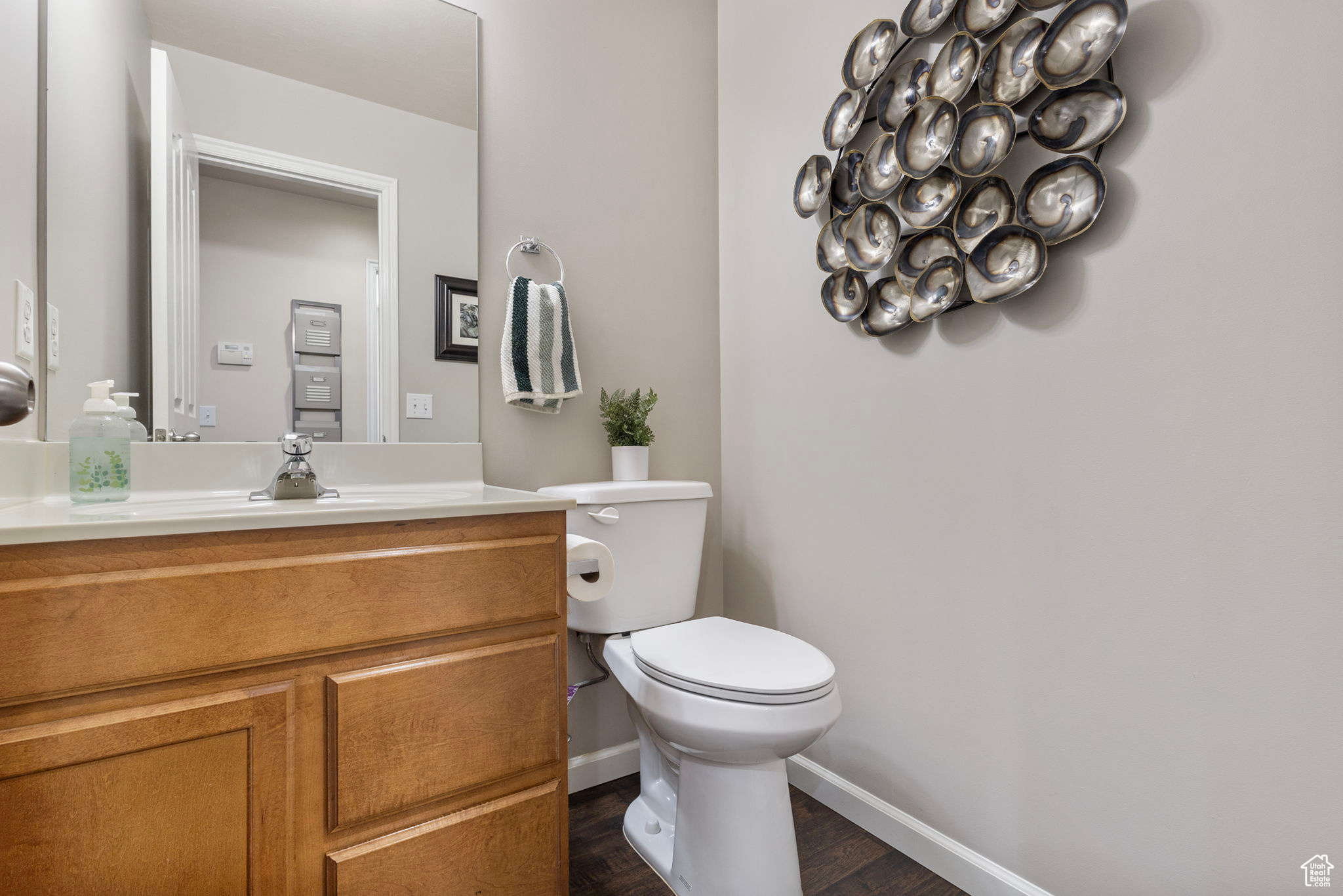 Bathroom with hardwood / wood-style flooring, vanity, and toilet