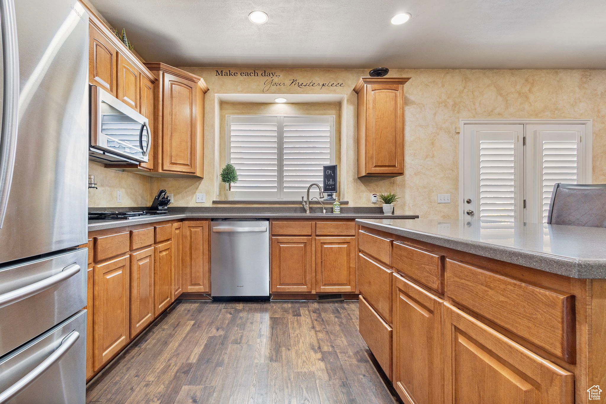 Kitchen featuring sink, stainless steel appliances, and dark wood-type flooring