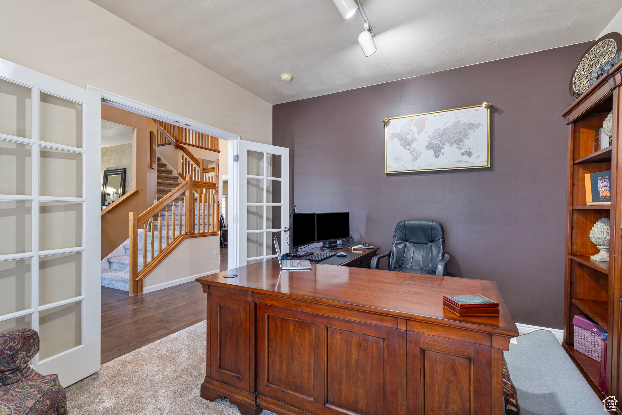 Office space with rail lighting, light carpet, and french doors