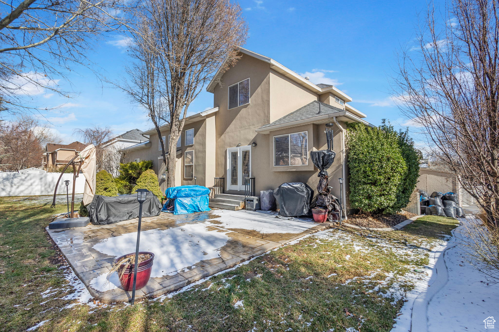 Snow covered house featuring a patio area