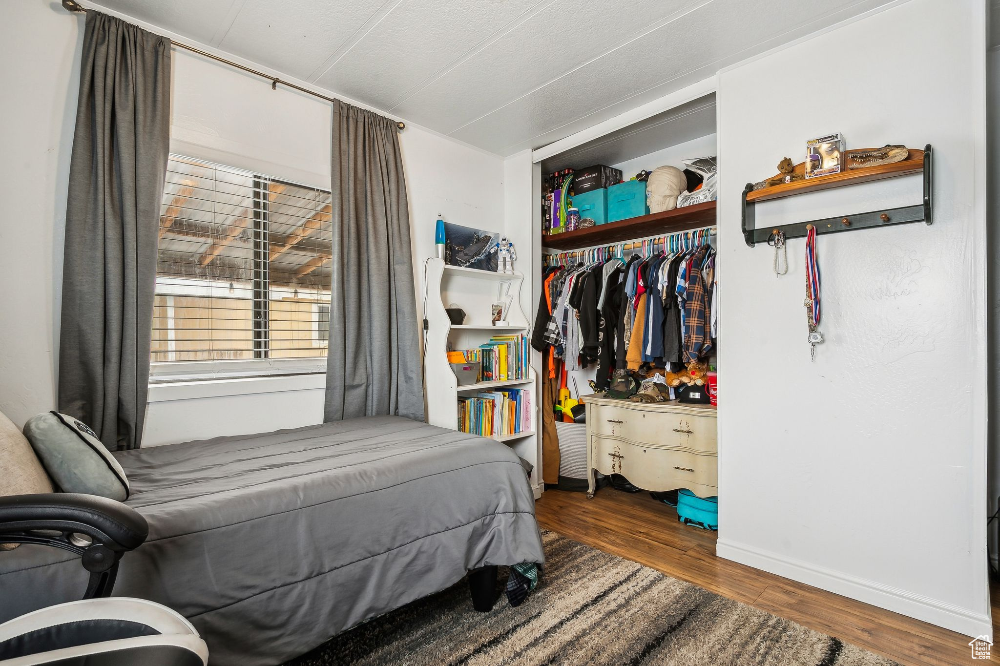 Bedroom with dark wood-type flooring and a closet