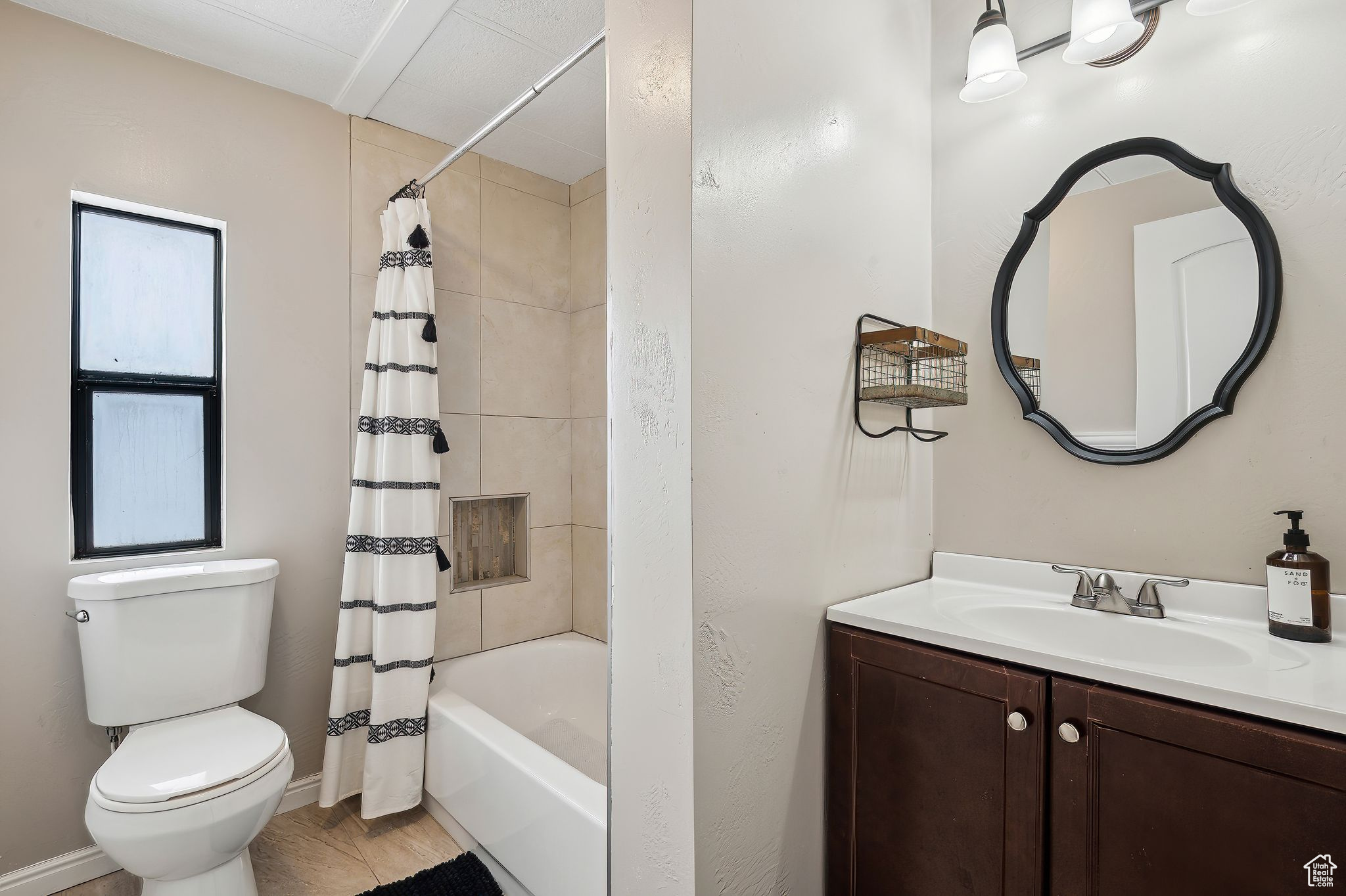 Full bath featuring toilet, shower / bathtub combination with curtain, baseboards, and vanity