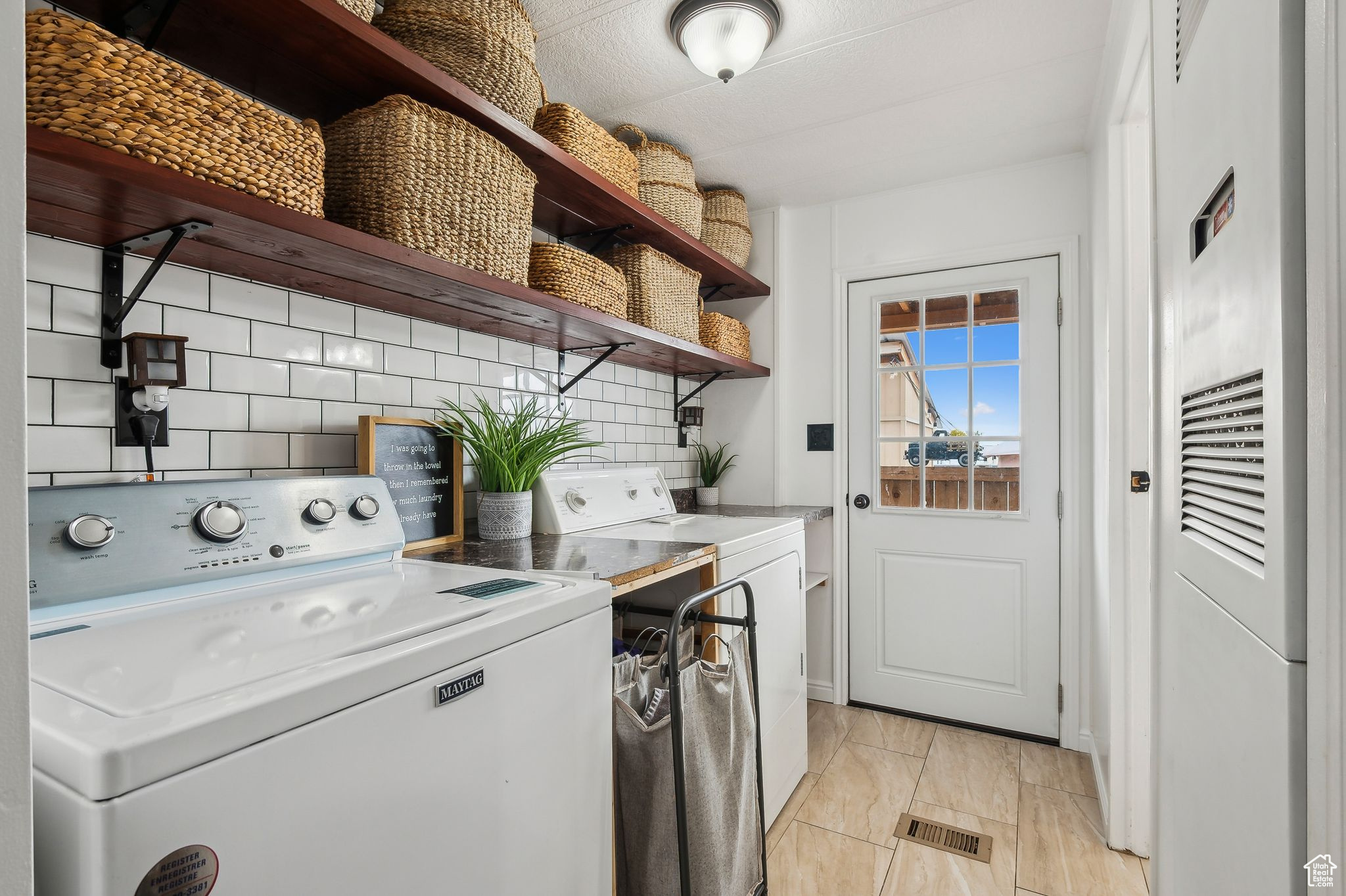 Washroom with laundry area, visible vents, and washing machine and clothes dryer