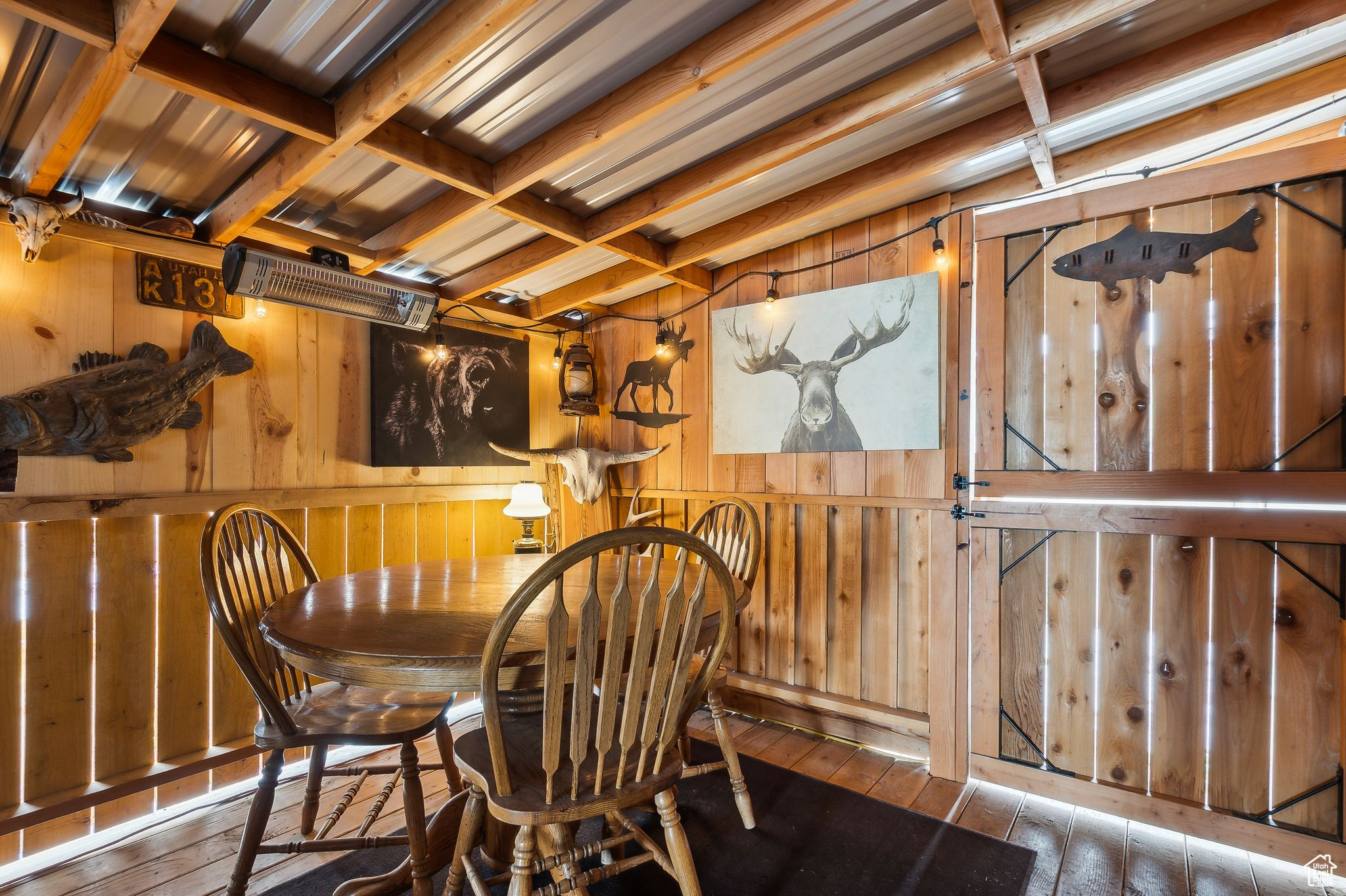 Dining space featuring wood walls, coffered ceiling, wood finished floors, and beam ceiling