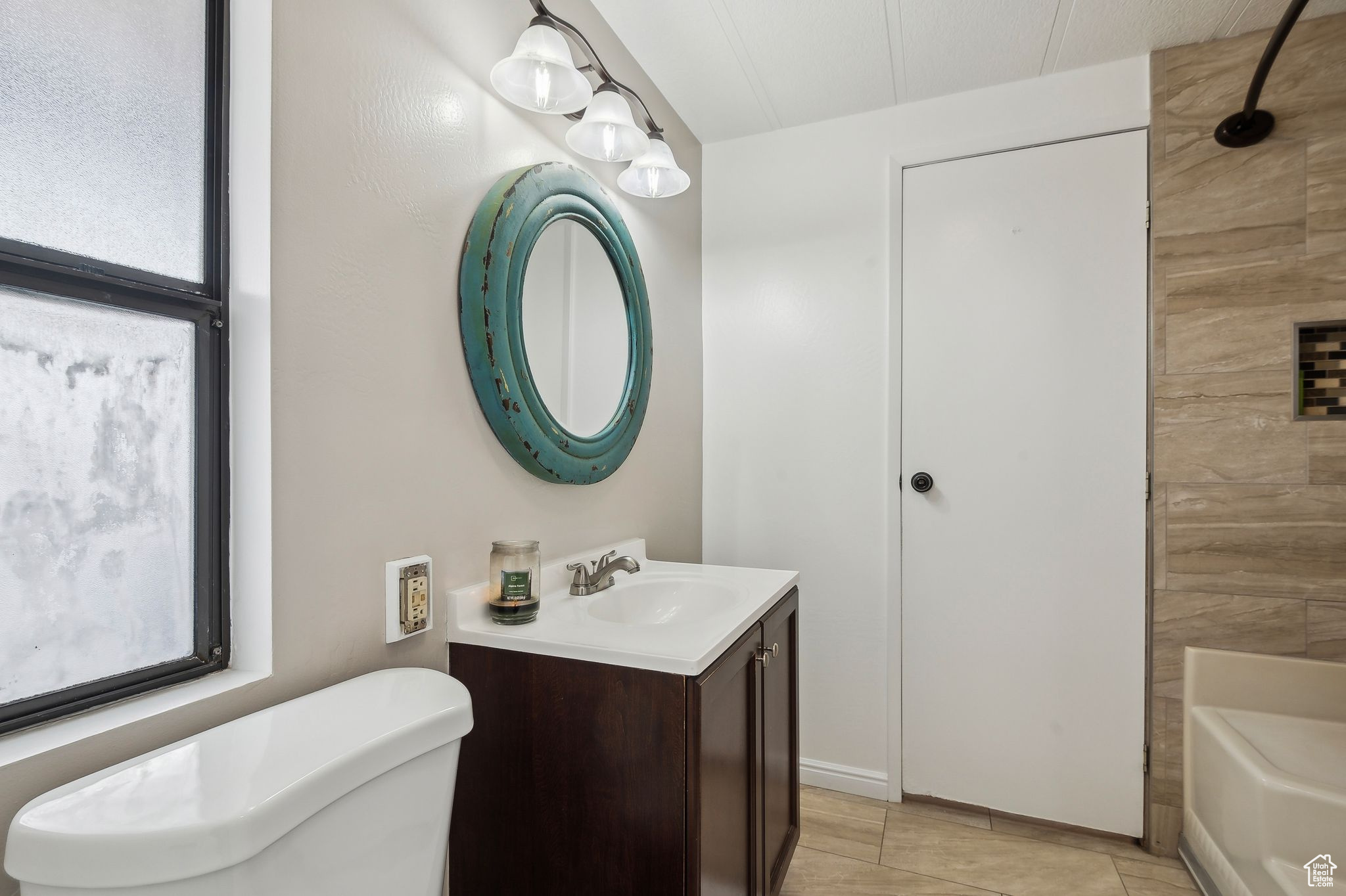 Bathroom featuring toilet, shower / washtub combination, and vanity