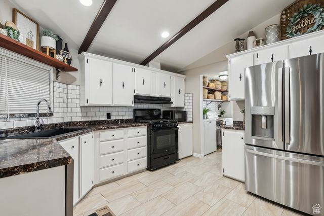 Kitchen with open shelves, white cabinetry, a sink, under cabinet range hood, and black appliances