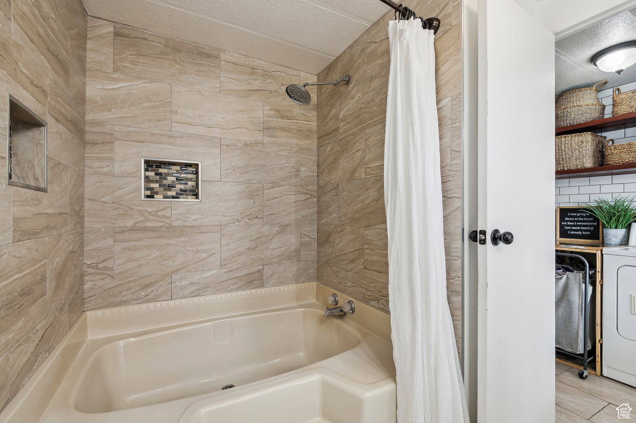 Bathroom with washer / clothes dryer and shower / tub combo