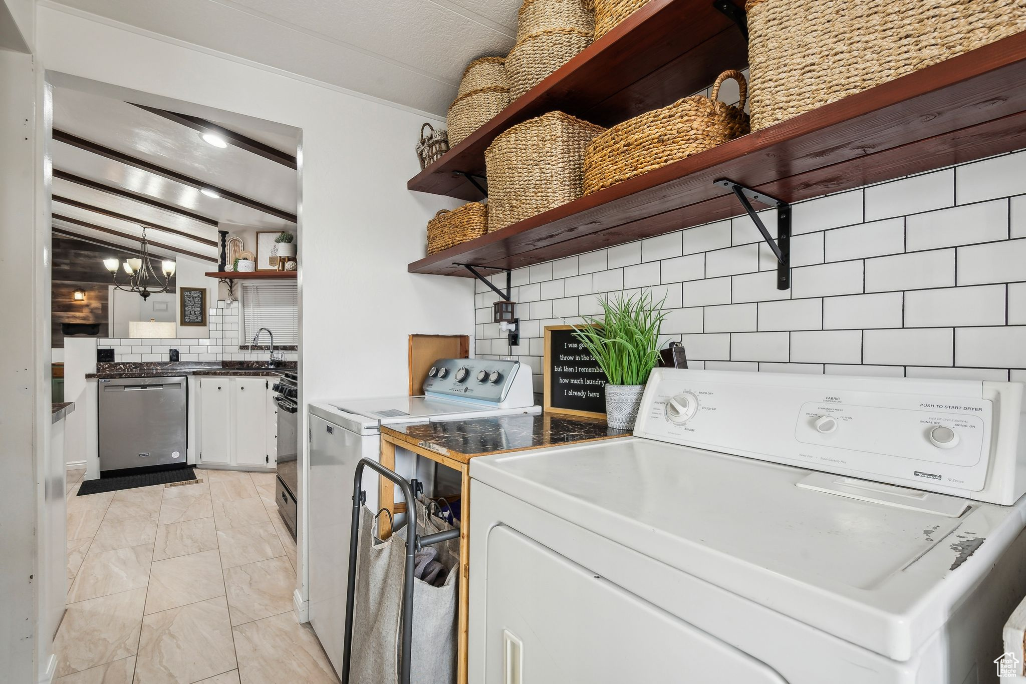 Washroom featuring laundry area, washing machine and dryer, a chandelier, and a sink