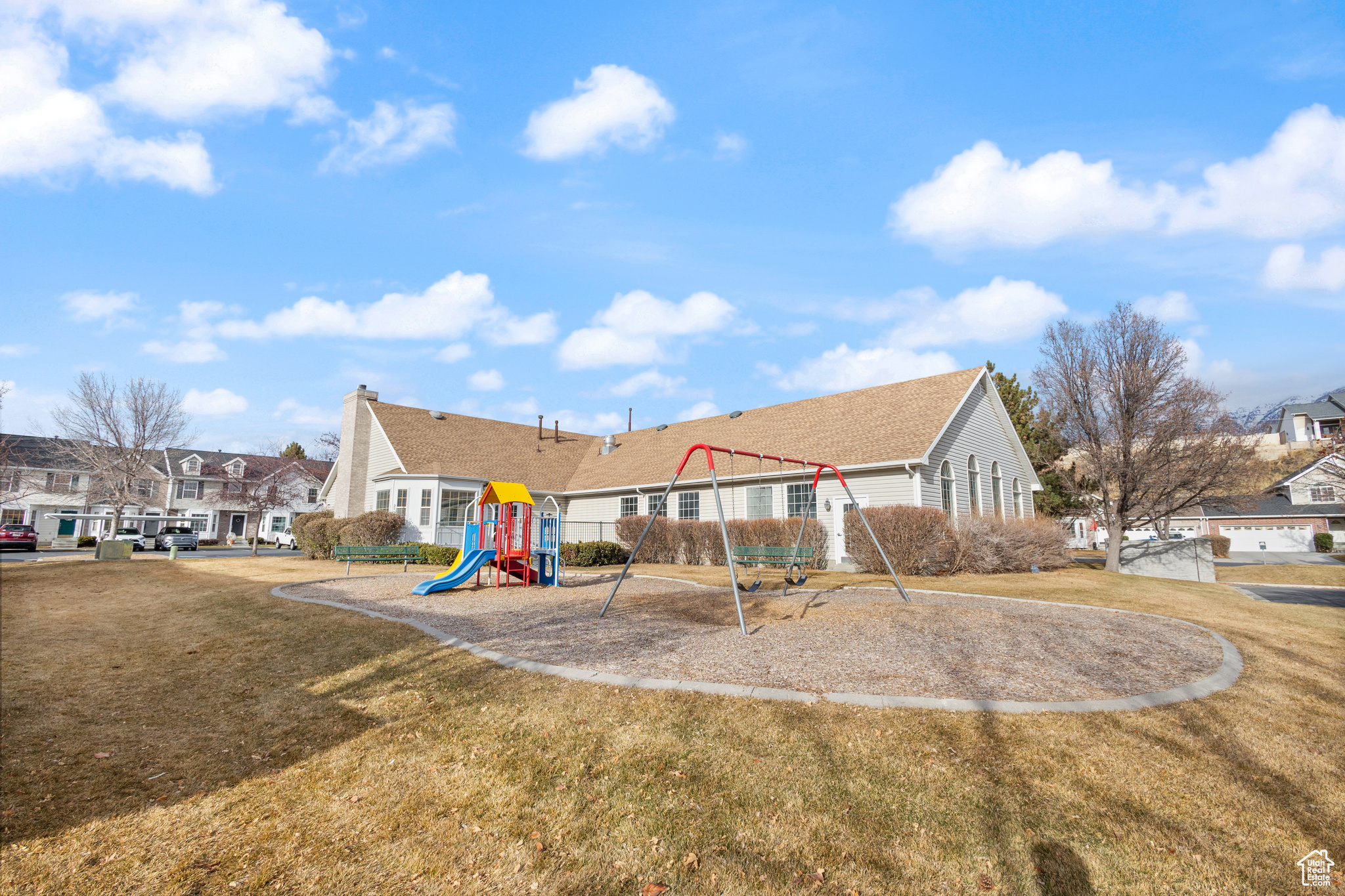 Back of property with a playground and a lawn