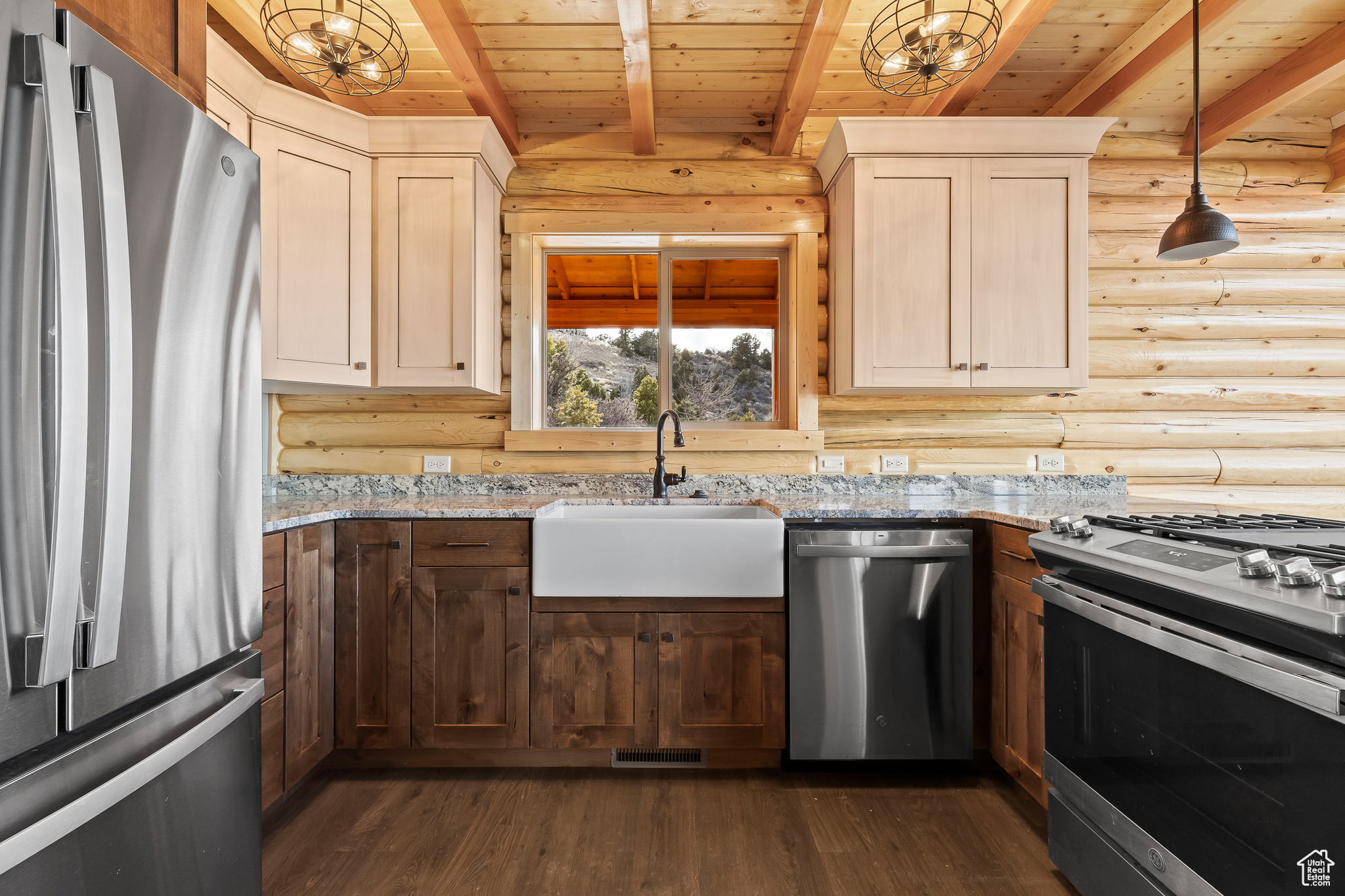 Kitchen with light stone counters, a sink, wood ceiling, appliances with stainless steel finishes, and pendant lighting