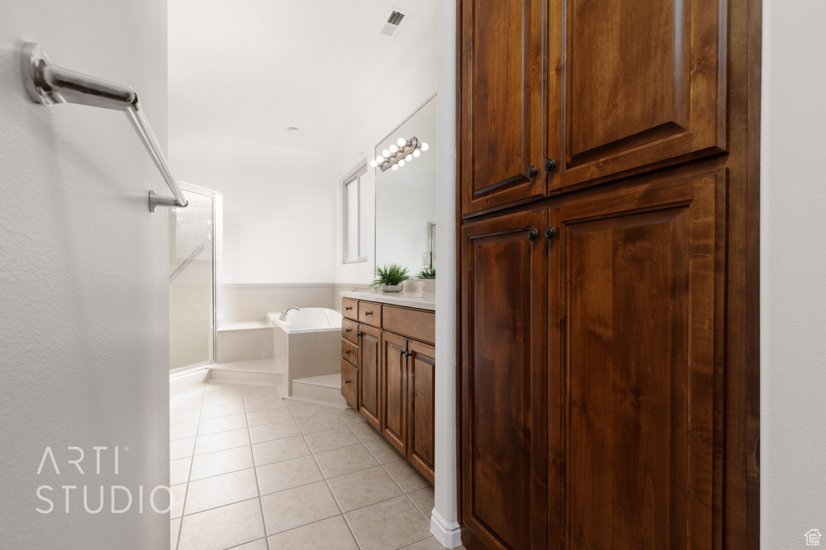 Bathroom with a washtub, vanity, and tile patterned floors