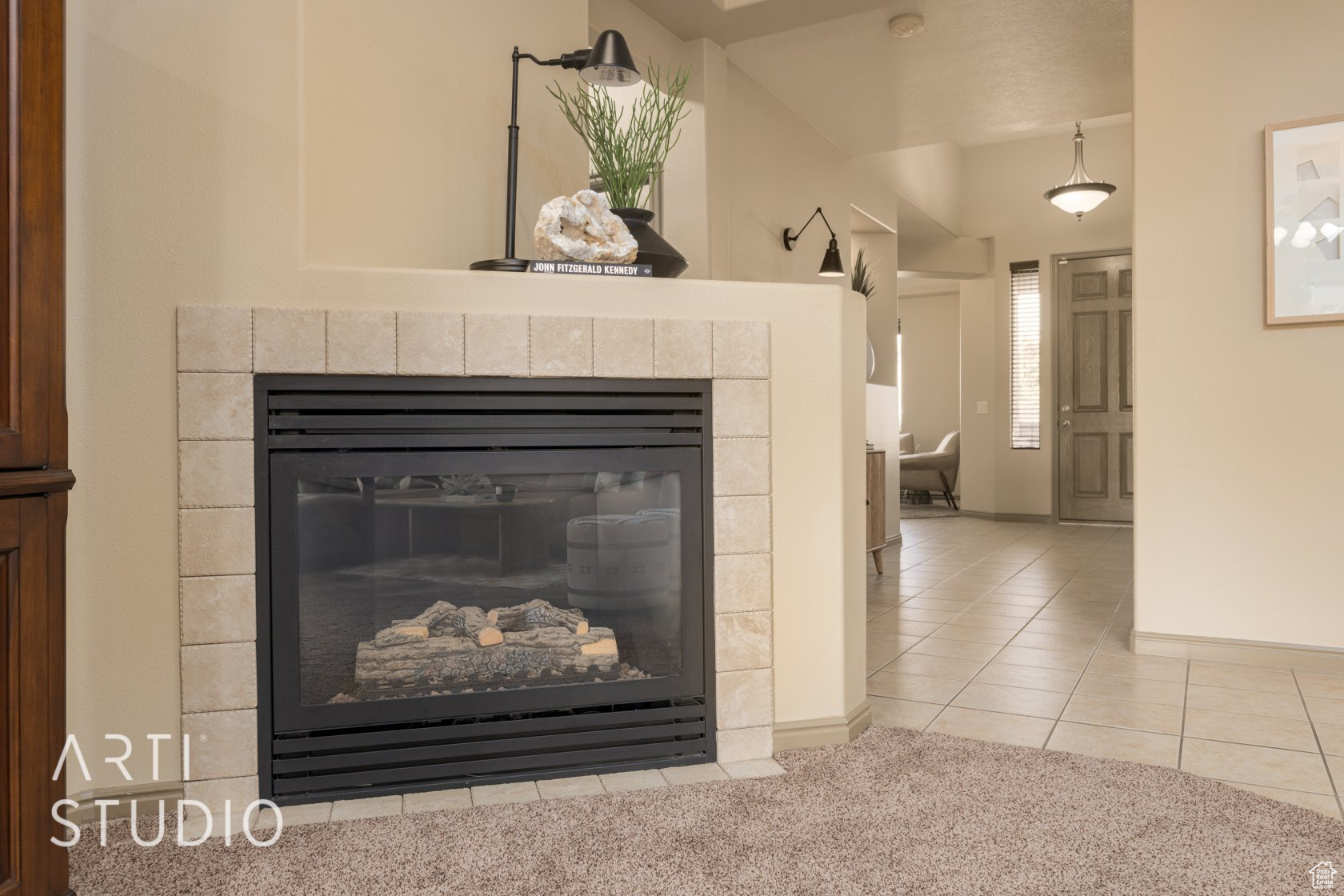 Room details with a tiled fireplace and carpet