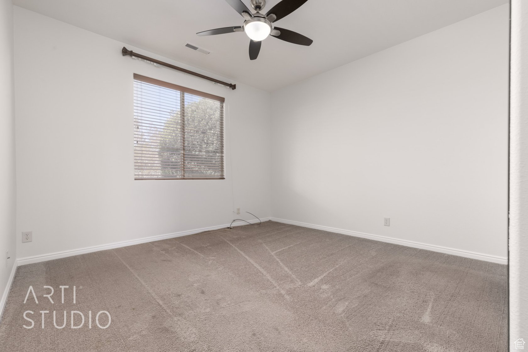 Carpeted spare room with ceiling fan