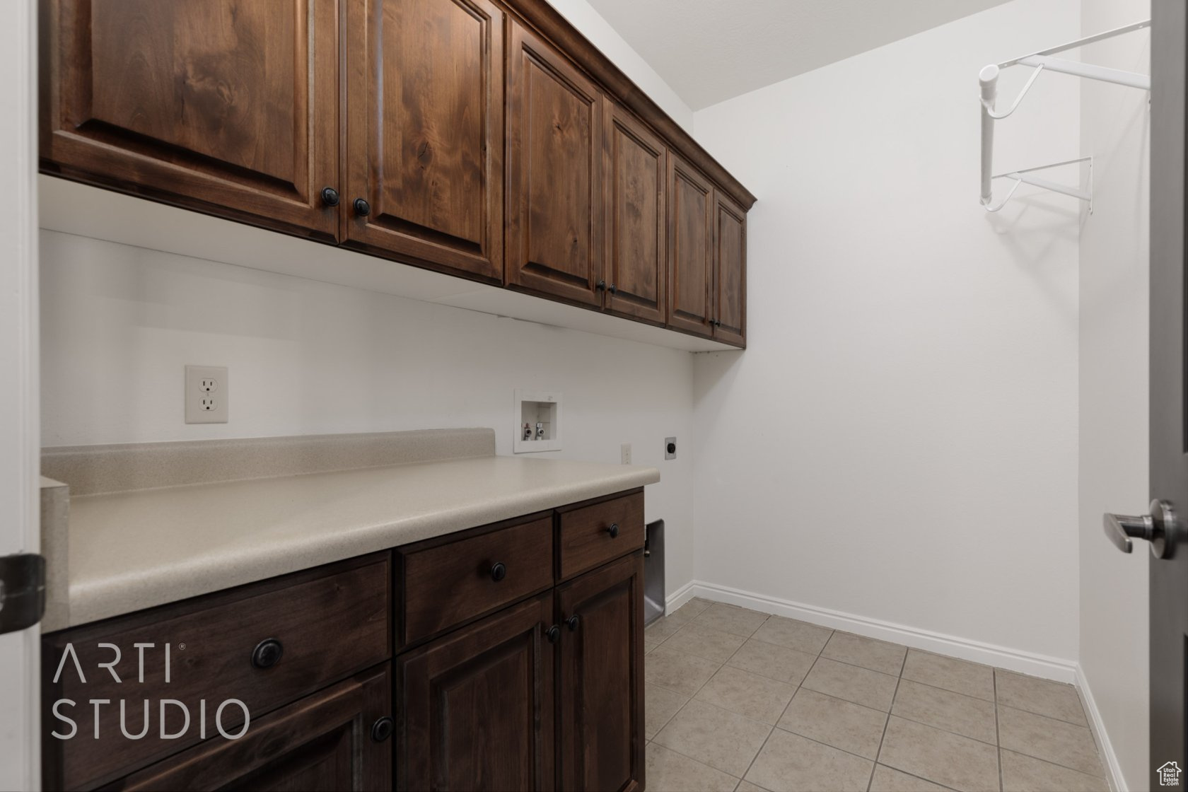 Clothes washing area featuring light tile patterned flooring, cabinets, hookup for an electric dryer, and hookup for a washing machine