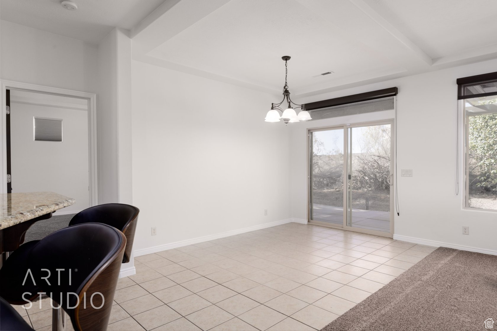 Dining space with a raised ceiling, light tile patterned floors, and a notable chandelier