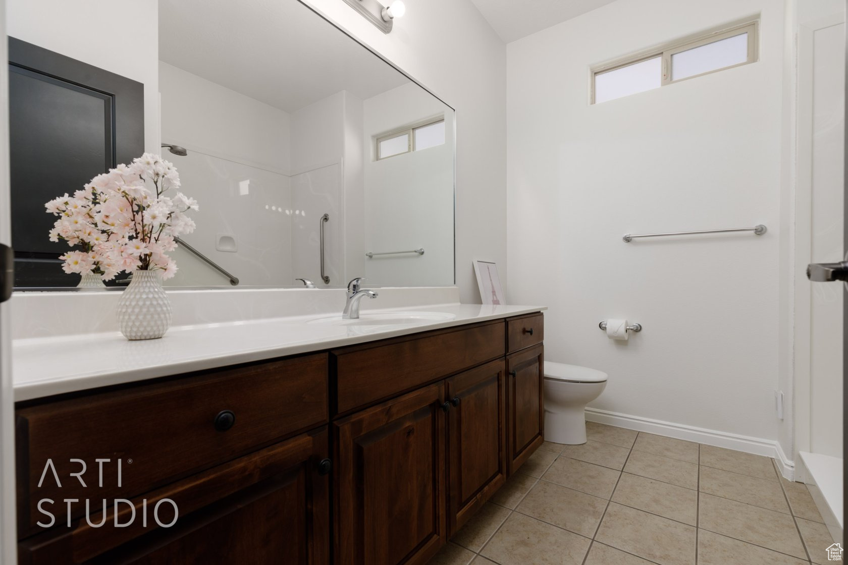 Bathroom featuring tile patterned flooring, vanity, toilet, and walk in shower