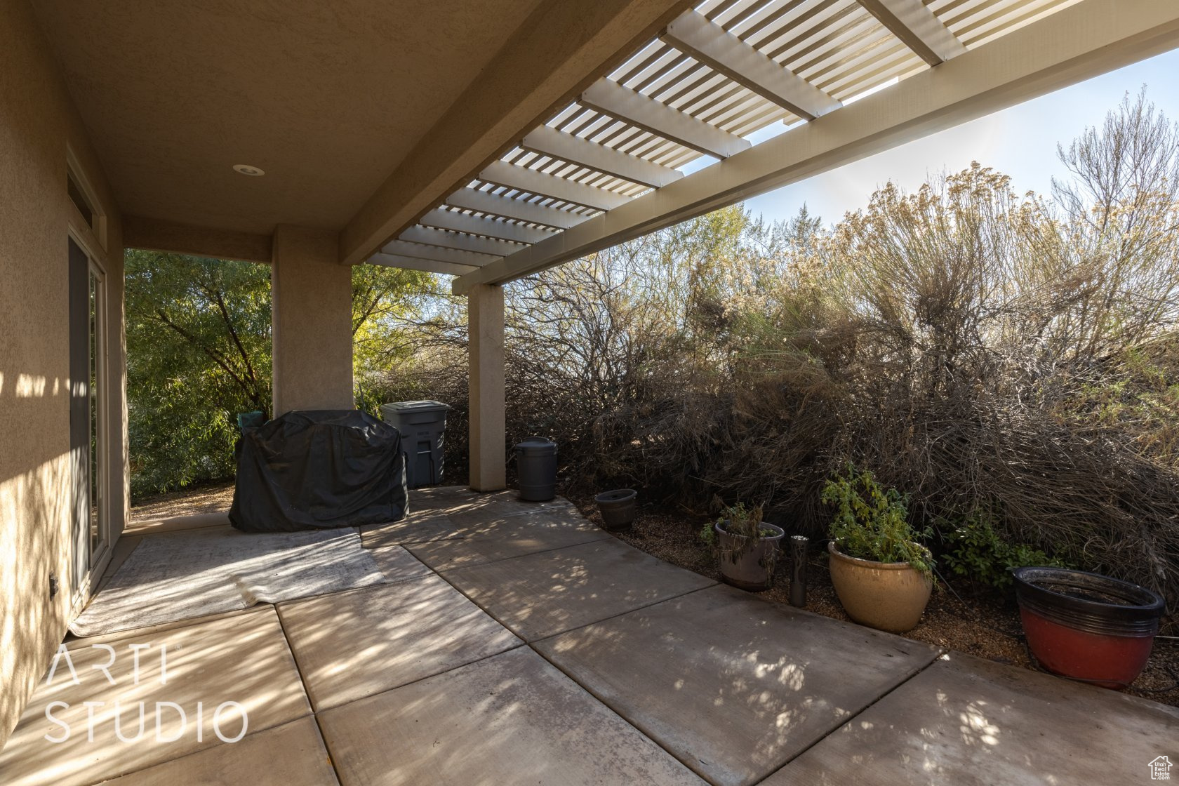 View of patio with grilling area and a pergola