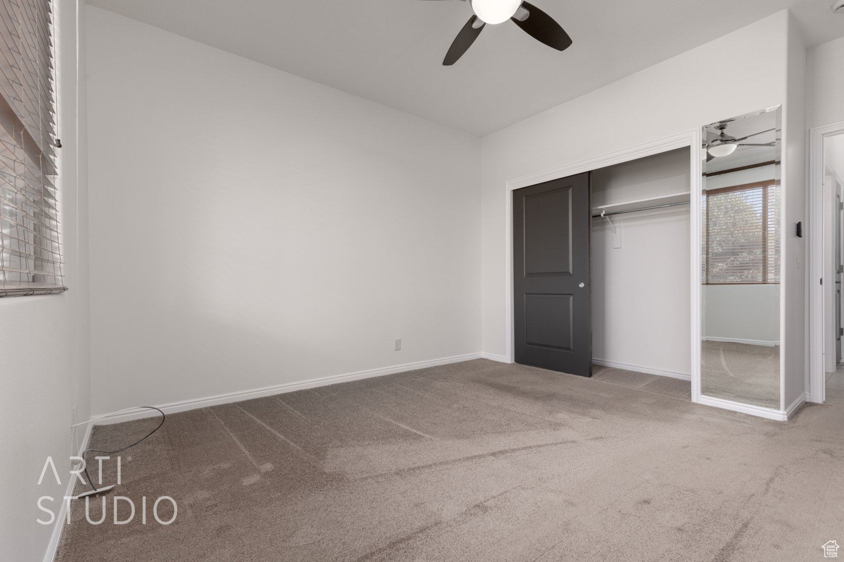 Unfurnished bedroom featuring carpet, ceiling fan, and a closet