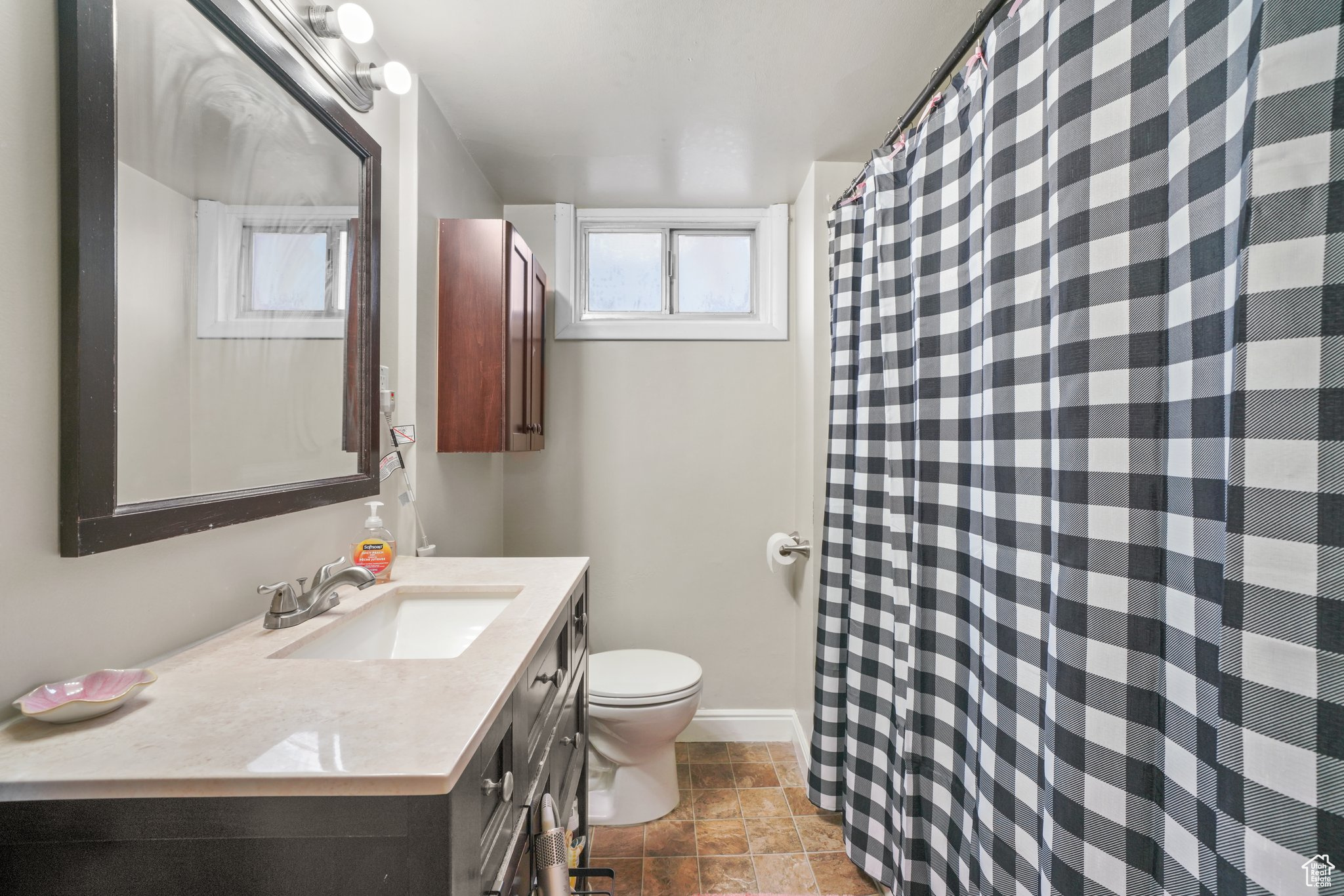Full bathroom with vanity, toilet, and baseboards