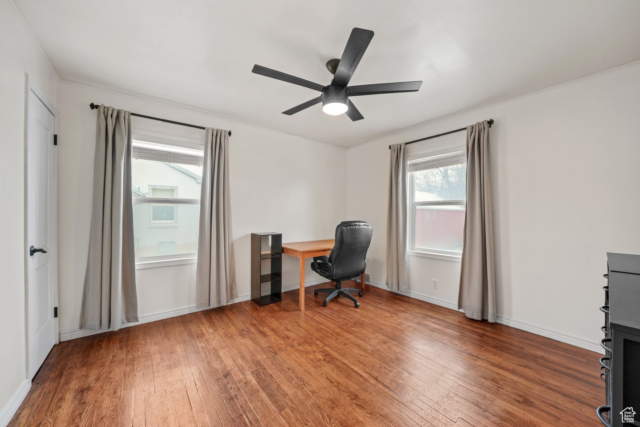 Home office featuring baseboards, a ceiling fan, and wood finished floors