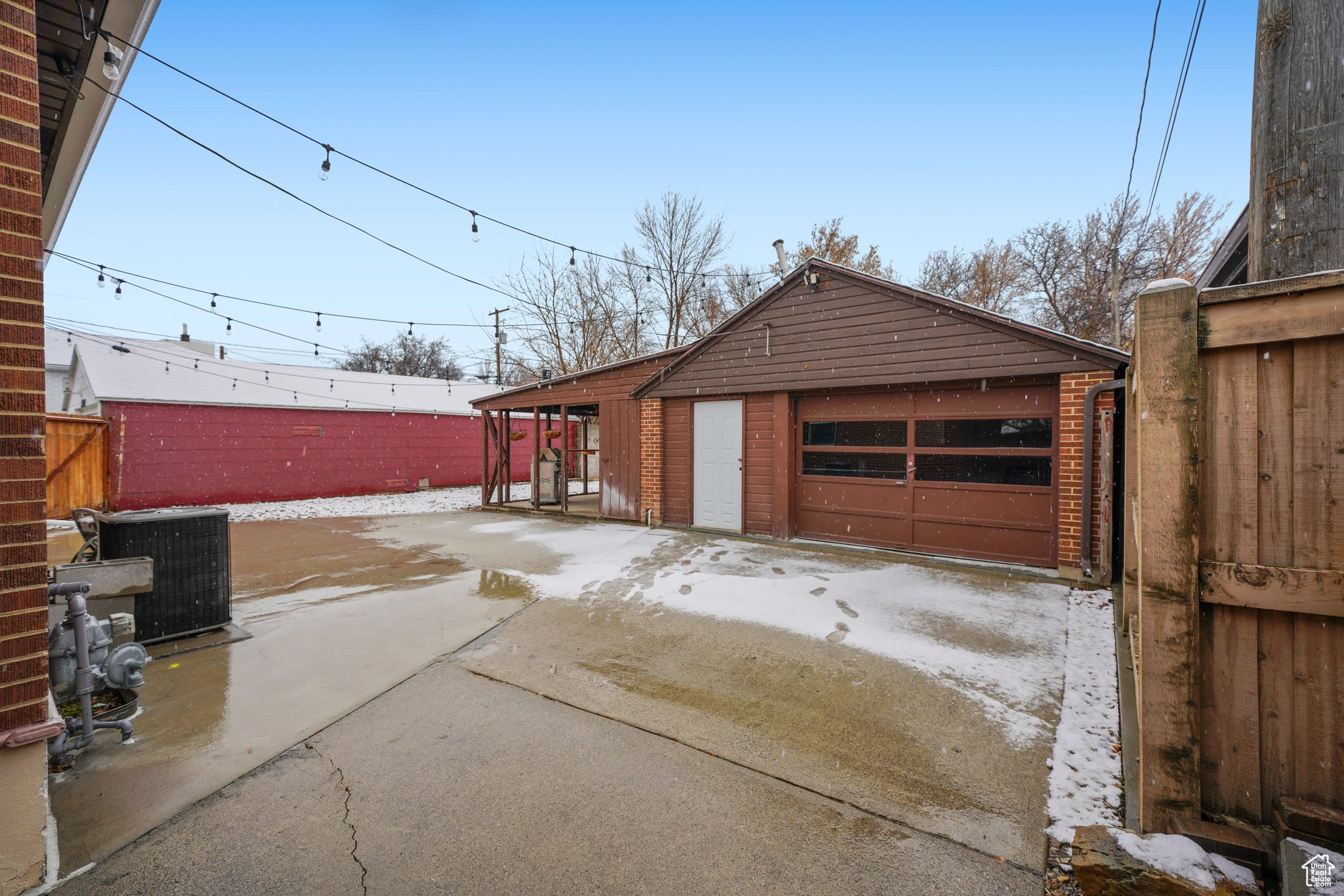 Detached garage featuring fence and central AC unit