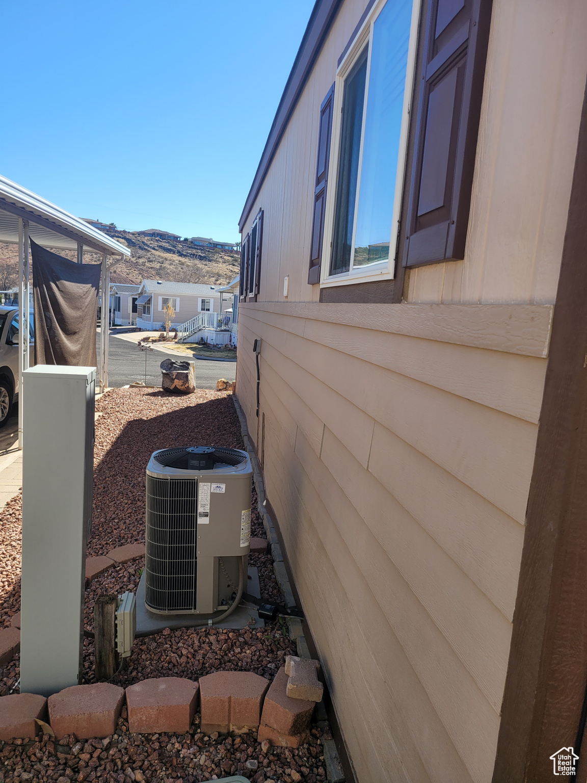 View of side of property with a mountain view and central AC unit