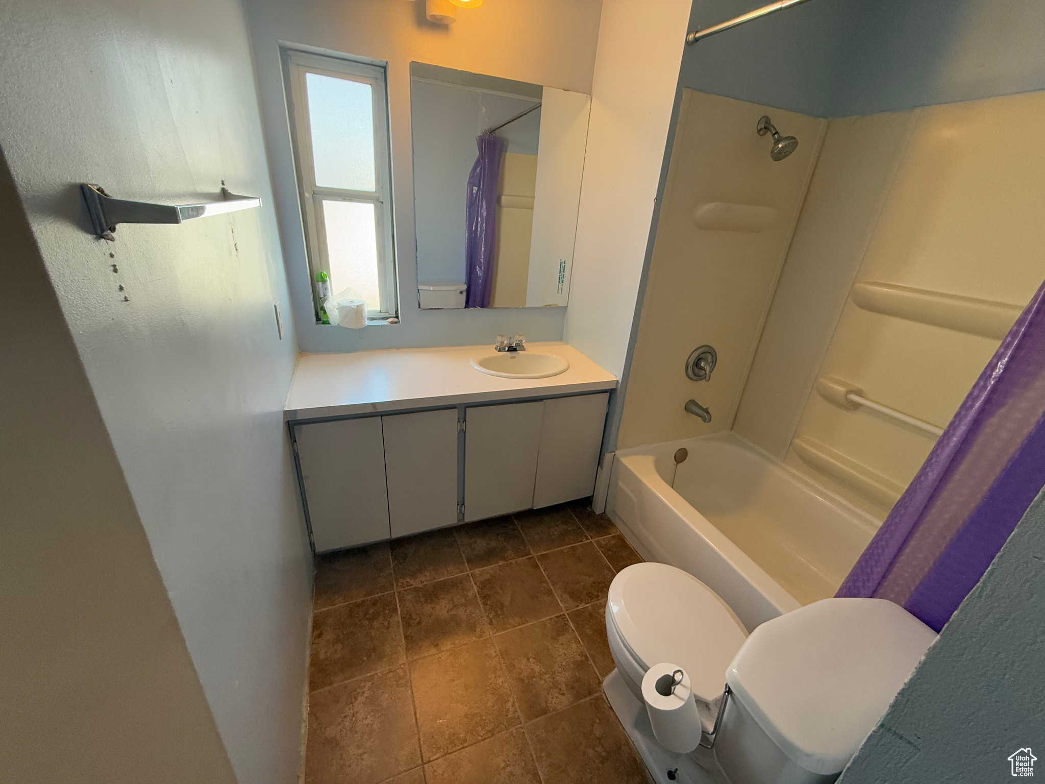Bathroom with vanity, toilet, and shower / bath combo with shower curtain