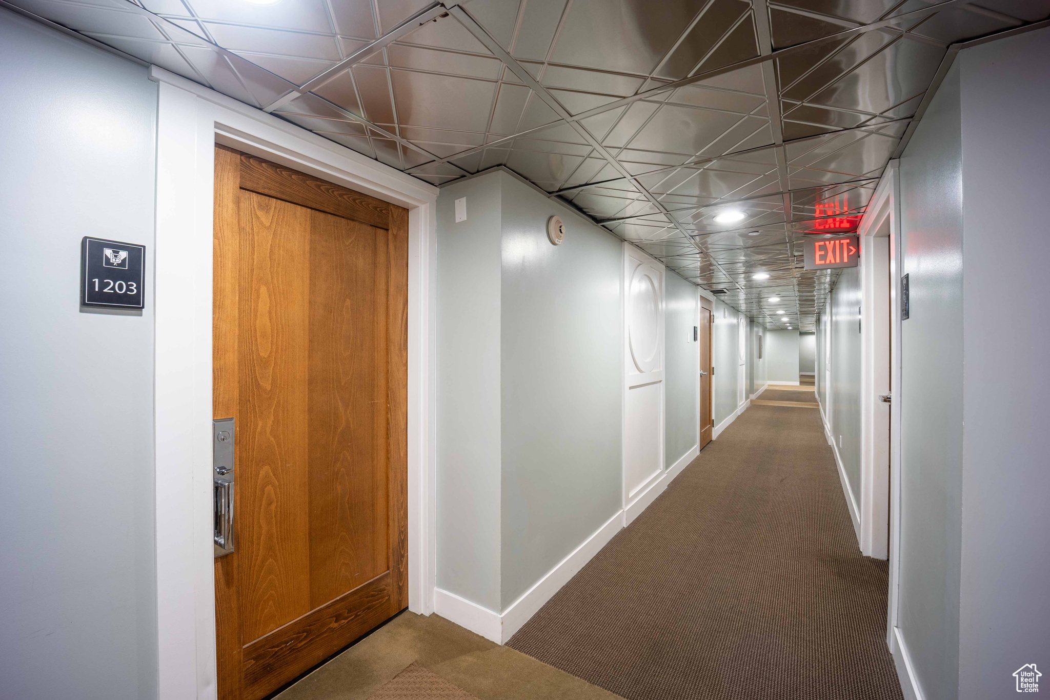 Hallway featuring carpet and baseboards
