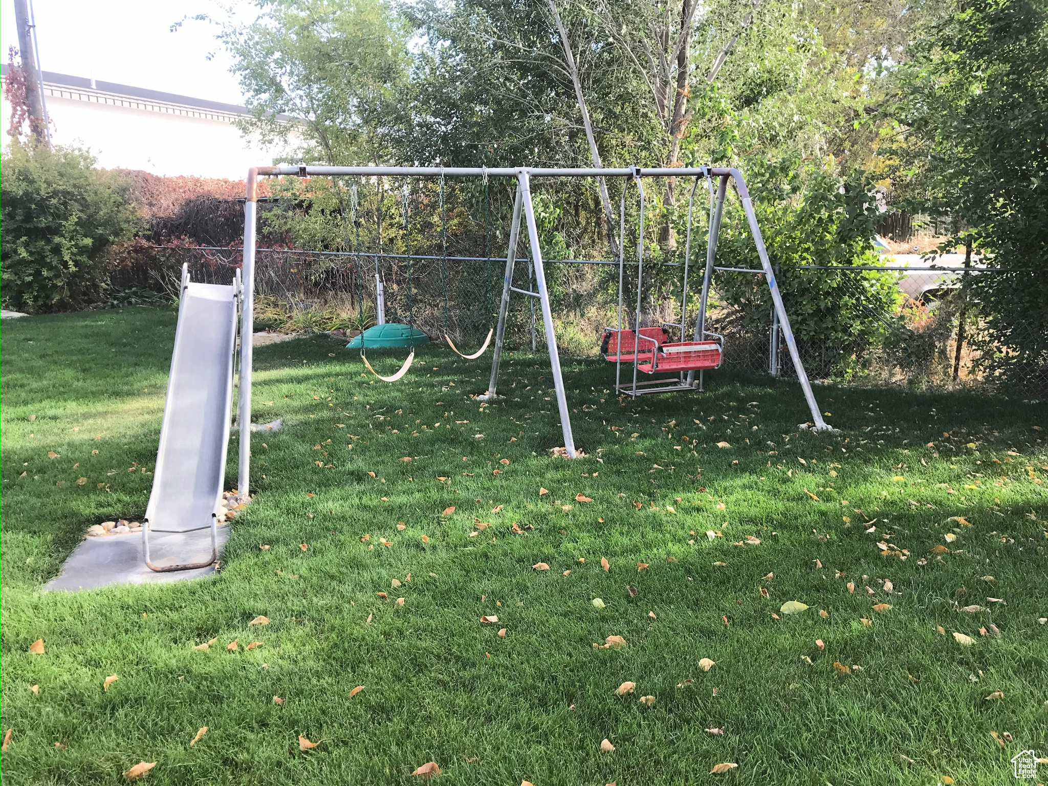 View of playground with a yard and fence